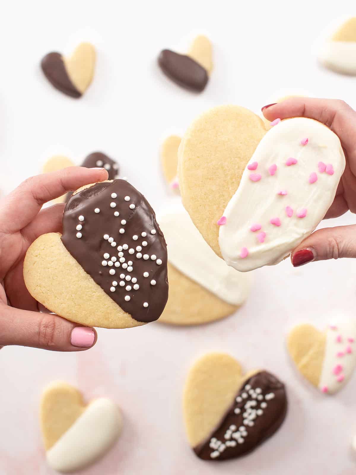 Overhead shot of Valentine's Day Cookies being held by two hands.